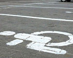 Кабмін пропонує Раді збільшити штрафи за паркування на місцях для інвалідів. паркомісце, паркування, штраф, інвалід, інвалідність, road, outdoor, street, way, city, corner, sidewalk, curb. A sign on the side of a road