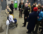 Кияни на візках показали, що станція метро “Лівобережна” для них недоступна. київ, метрополітен, пандус, підйомник, інвалідність, person, wheelchair, clothing, outdoor, footwear, man, bicycle, crowd. A group of people standing on a sidewalk