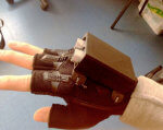 Одесские школьники создали «умную» перчатку, которая облегчит жизнь незрячим людям. glass glover, изобретение, незрячий, ограниченными возможностями, умная перчатка, indoor, box. A hand holding a piece of paper