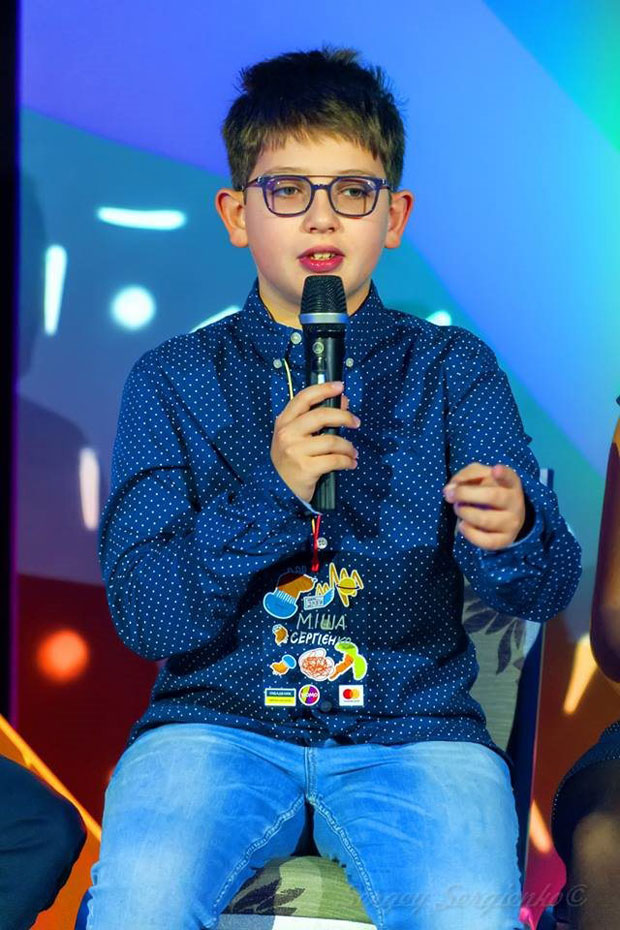 Как 11-летний мальчик с аутизмом помогает другим детям с такими же особенностями. миша сергиенко, адвокація, аутизм, аутист, діагноз, person, human face, scene, clothing, microphone. A person sitting on a stage